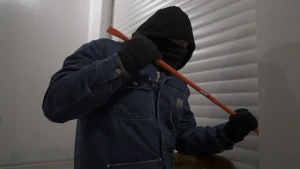 Sagoma di uno scassinatore che tenta di forzare la tapparella di sicurezza mediante un piede di porco